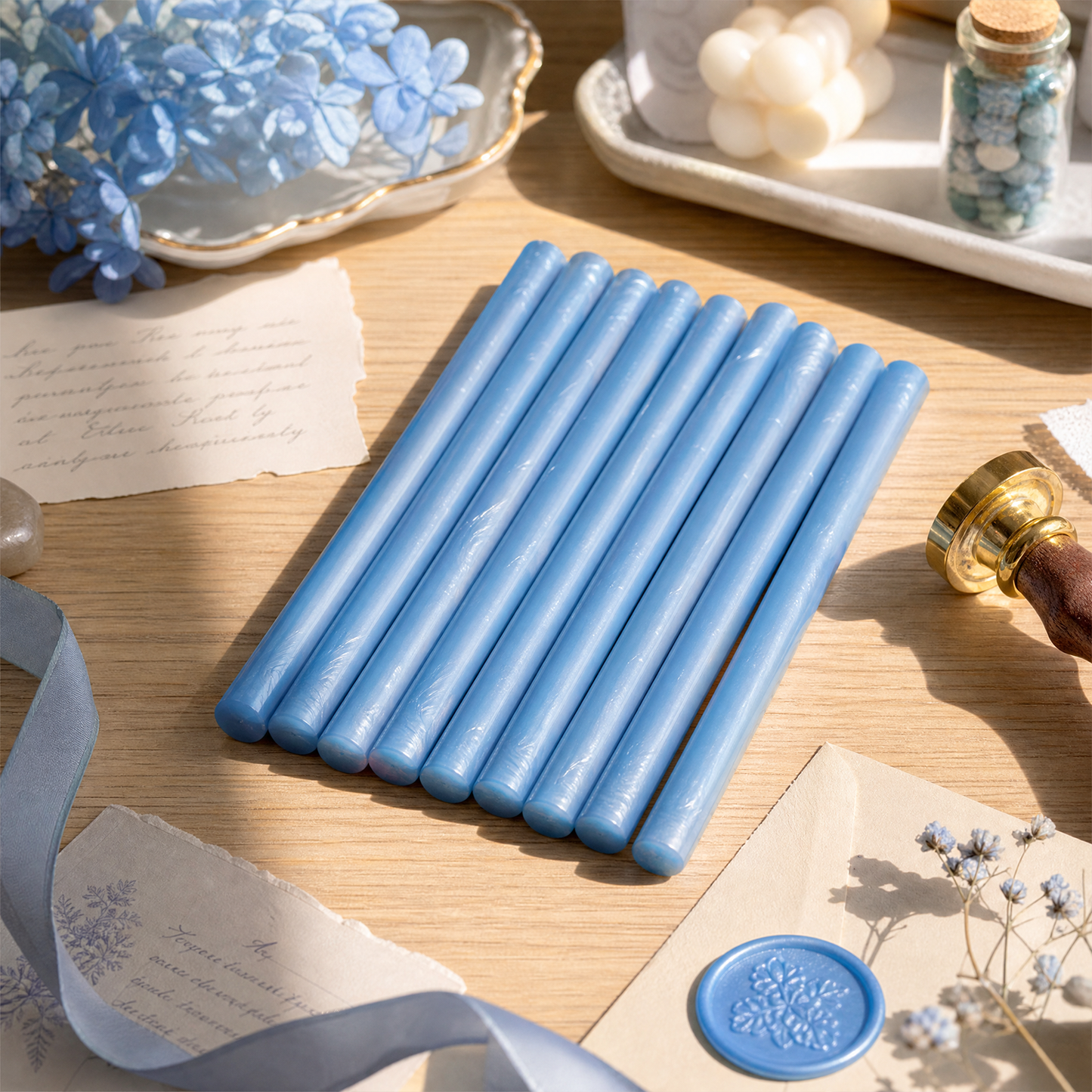 Blue sealing wax sticks on writing desk with wax seal stamp flowers and stationery