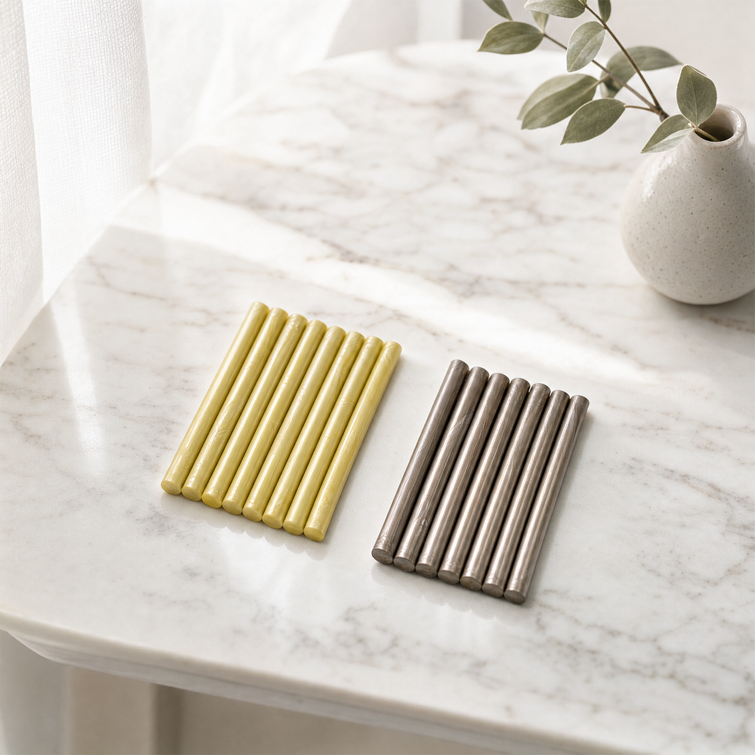 Pearl yellow and champagne gold sealing wax sticks on marble table with minimalist decor